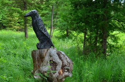 Sculpture d’argile corbeau sur une souche