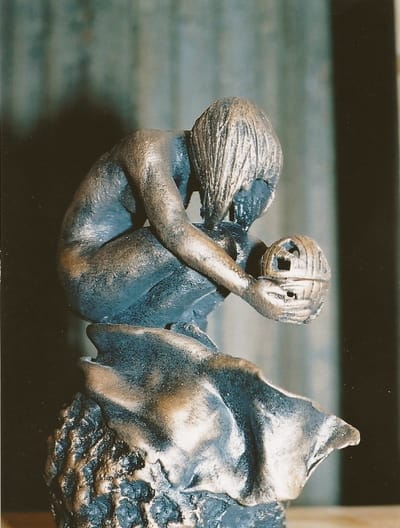 sculpture d'argile personnage accroupit tenant une sphere